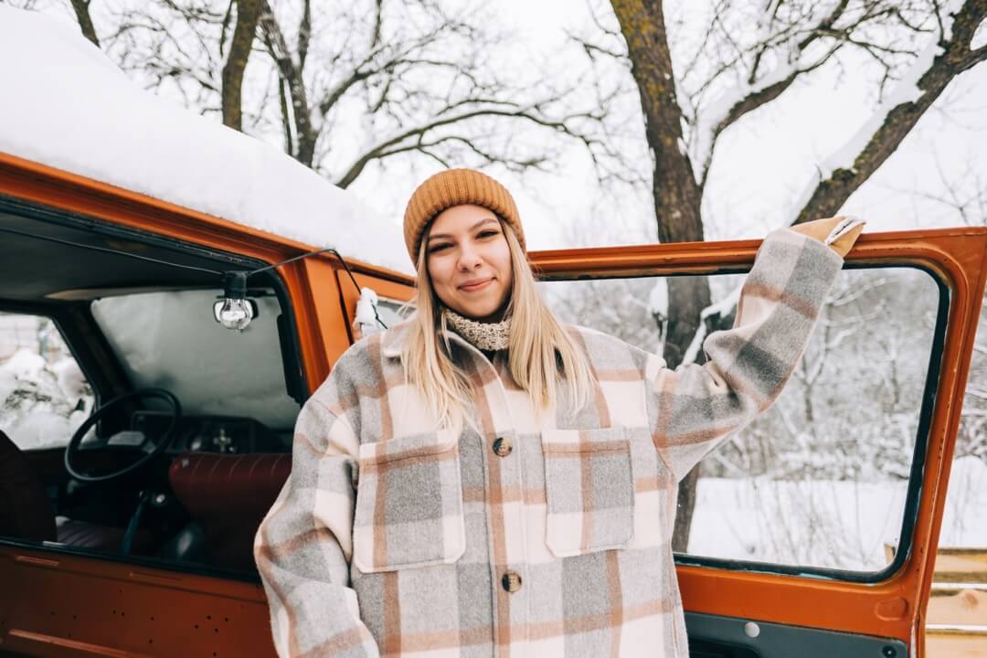 Fille souriante fermant la porte de sa roulotte pendant l'hivernage.